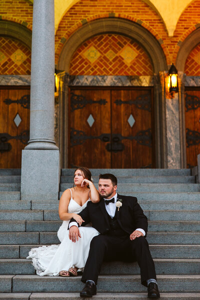 Bride and groom sitting on steps in front of a church - St. Cloud, Minnesota