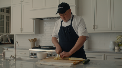 Man in kitchen cutting vegetables-FillmCo