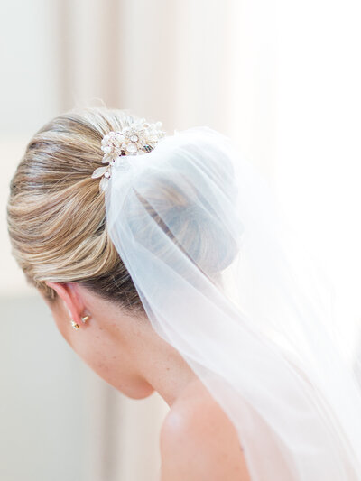 Bridal hair updo with white hair piece and veil