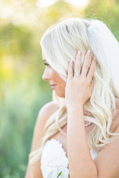 Bride holding hair back and showing off engagement ring at Circle Oak Ranch in Fallbrook, California by San Diego Photography & Videography team, Sherr Weddings.