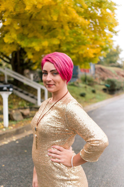 A young woman with pink hair poses in downtown Fredericksburg