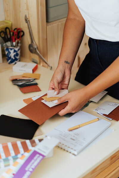 woman sorting paper swatches for custom invitation stationery