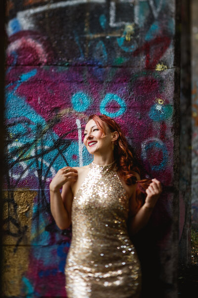 woman in gold dress with graffiti