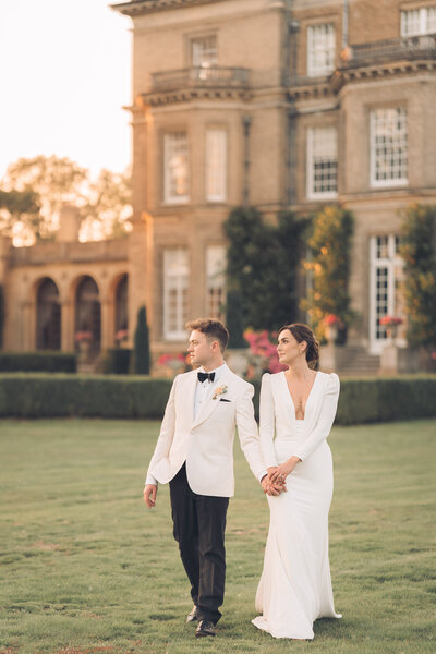 bride and groom walking on grass