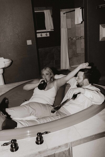 bride-drinking-champage-in-tub-with-groom
