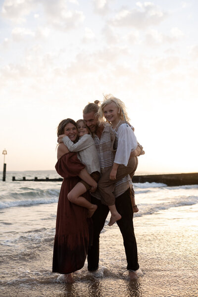 family hugging photo coastline
