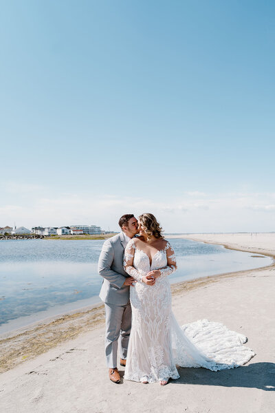 newlyweds stand on beach