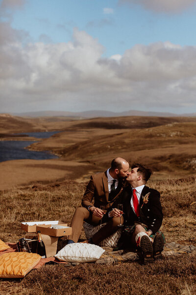 grooms embrace at elopement picnic