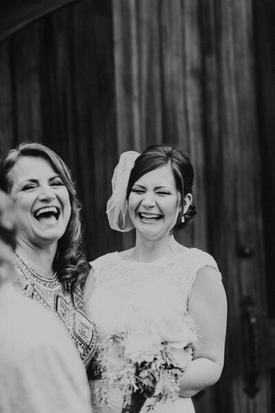 Bride laughs with her mother at her wedding