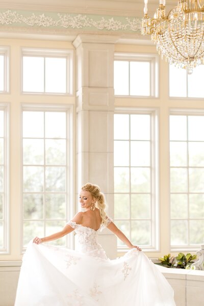 Bride twirls in front of large open windows at Lake Como Estate wedding.