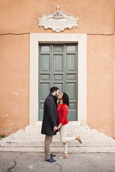 A couple standing in front of a door in the roman forum. Taken by Rome Engagement Photographer, Tricia Anne Photography.