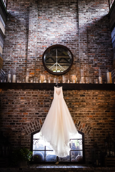Gown hanging on fireplace, dramatic dress shot, Greengates Farmhouse, Laurel, MS, Mississippi Wedding