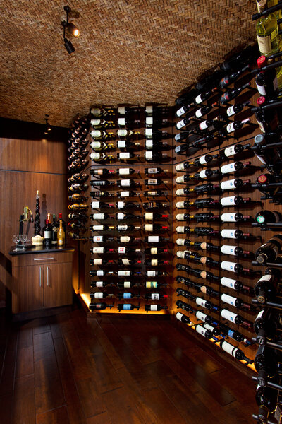 Dark wood wine room with wall covered in wine bottles