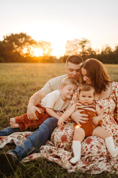 family holding little kids at golden hour