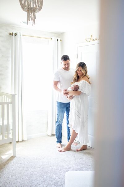 Parents looking at newborn baby in nursery taken by nj newborn photographer