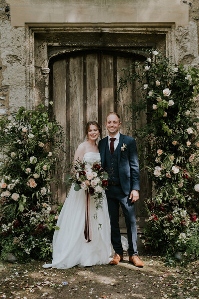 Bride and goom posing for portrait in front of church door