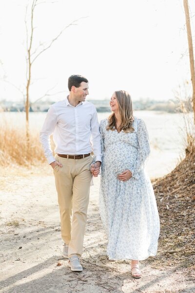 A couple walks on the beach during their maternity session photographed by New Jersey Maternity Photographer Kate Voda Photography