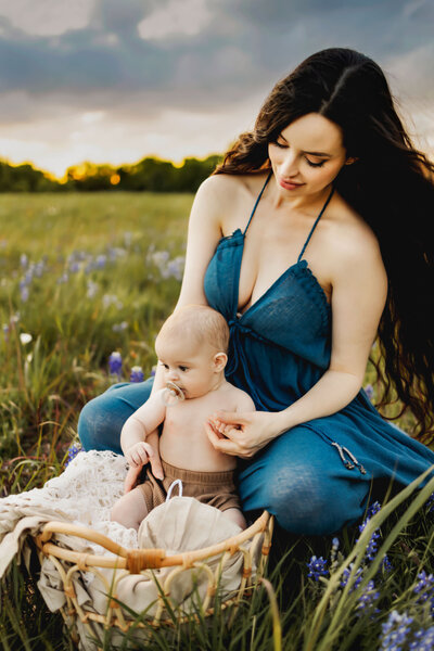 mother with baby in bluebonnets