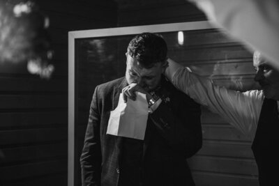 Groom shedding a tear during his speech and getting comforted by his father in law