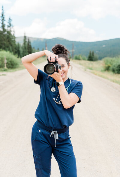 Rachel in scrubs with stethoscope around neck and camera in hand