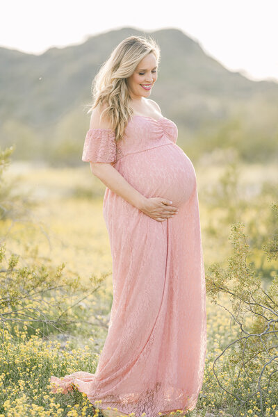 pregnant woman standing in desert mountain range