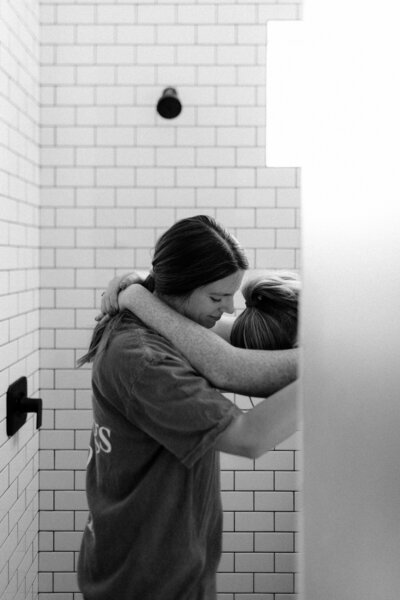 Doula offering emotional support during early labor in home birth setting