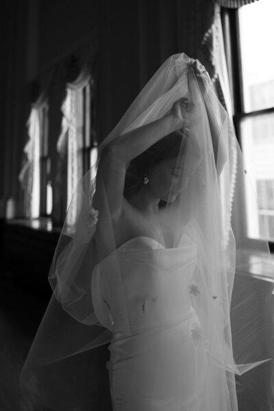 Bride holding veil above her head