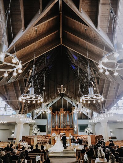 A Texas wedding ceremony in a church with chandeliers captured by a talented wedding videographer.