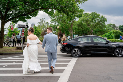 Bride and groom holding hands while crossing city street after ceremony – photographed by wedding photographer Niko Coric – Lumen Clarity Media