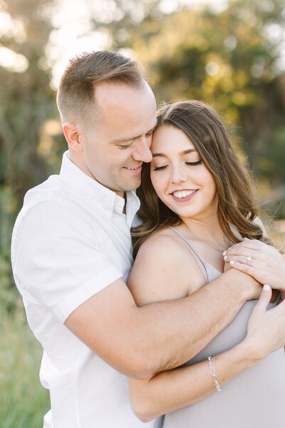 close-up shot of engaged couple smiling and embracing in outside nature area in sonoma county.