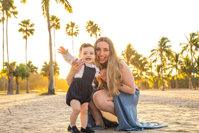 Mother poses with son at the beach during the sunset