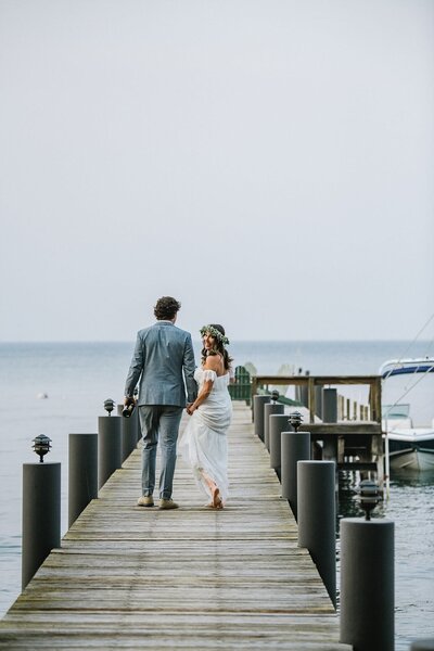 Bride and groom walking on pier towards their boat after their ceremony of their micro wedding in Lake Tahoe during fire season