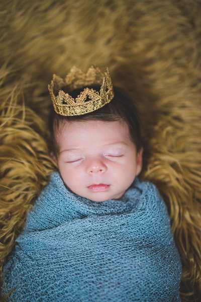 newborn photography session of baby in grey blanket and golden crown