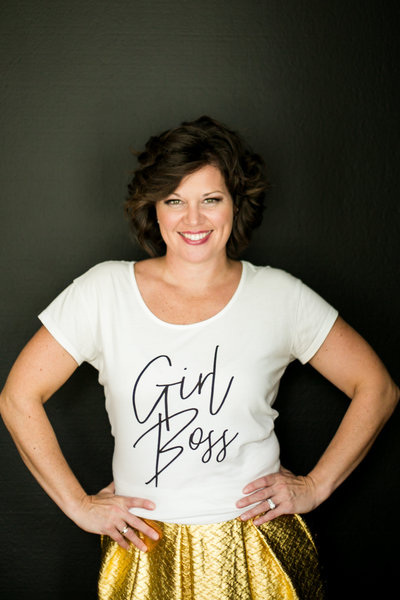 Female entreprenuer smiles for photo in a Girl Boss t-shirt