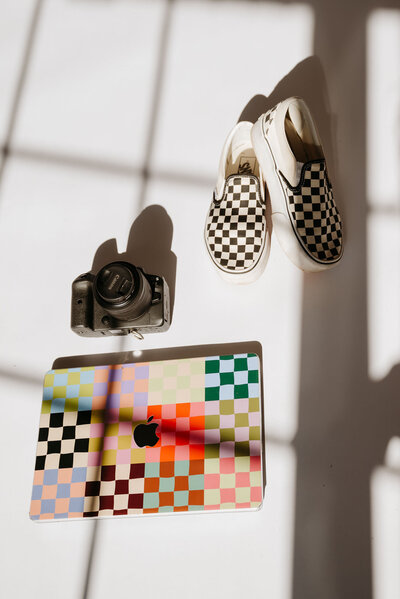 laptop, camera, and shoes with checkered print
