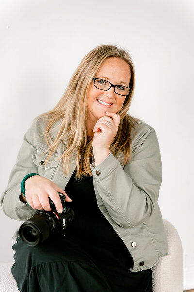 Jennifer Maren, an Eau Claire Wedding Photographer,  smiles while holding camera