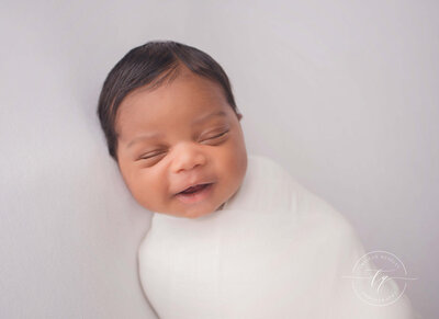 Smiling newborn during his baby photoshoot