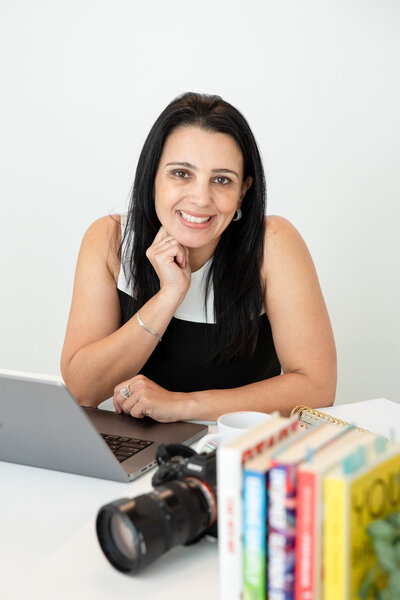 photo of a brand photographer in her desk with laptop, camera and favorite books