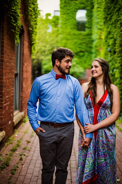 Couple holding hands and walking through Modern Tool Square for engagement photos  in Erie, PA