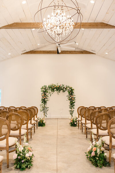 indoor wedding ceremony with. chairs and flowers