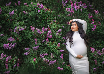 gorgeous pregnant woman posing in form fitting white dress