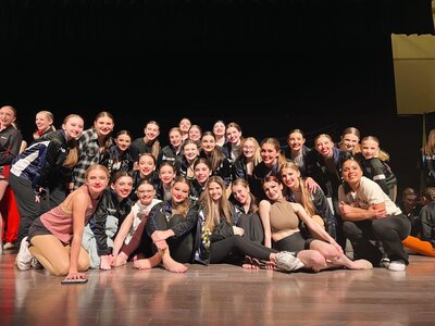 competitive dancers posing on stage at competition