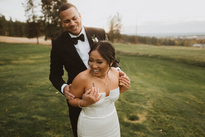 couple laughs together during sunset photos at their wedding reception at Beacon Hill in spokane washington
