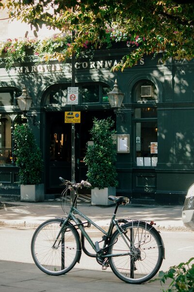A bike, leaning against a rest on a street of England.