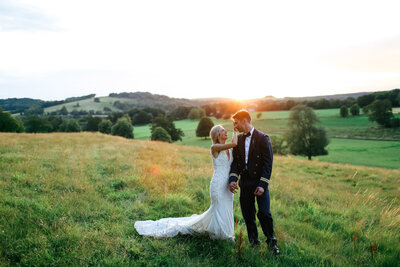 couple-hold-hands-in-countryside-at-luxury-wedding-in-hampshire