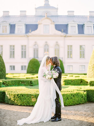 bröllop på kronovalls vinslott brud och brudgum poserar i slottets trädgård