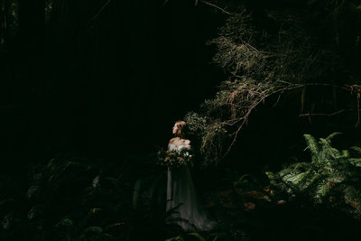bride standing in forest