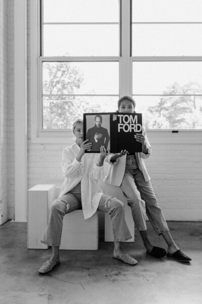 Two women holding a tom ford book