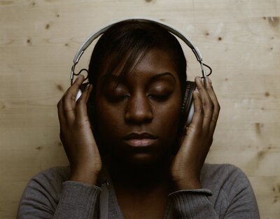 Black woman engaging in sound therapy with headphones for nervous system regulation