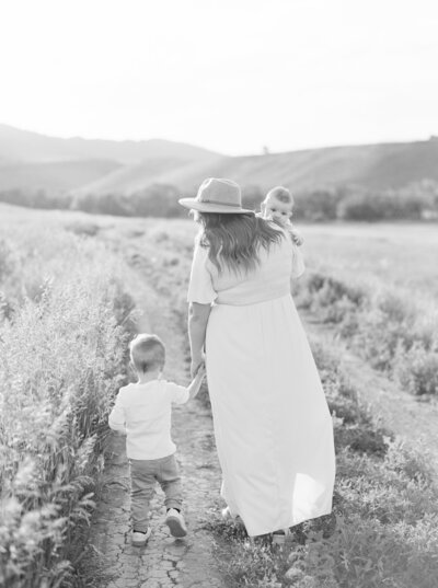 Mother walking in grass with two boys Denver Family Newborn Photographer